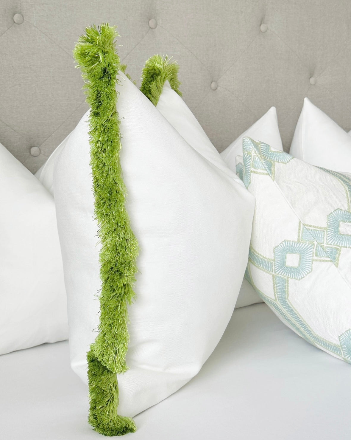 Custom-made Schumacher white throw pillow cover with vibrant apple green fringe. Crafted from luxurious designer fabric, this pillow adds a pop of color and texture to modern or coastal decor. Ideal for living rooms, bedrooms, or sofas.