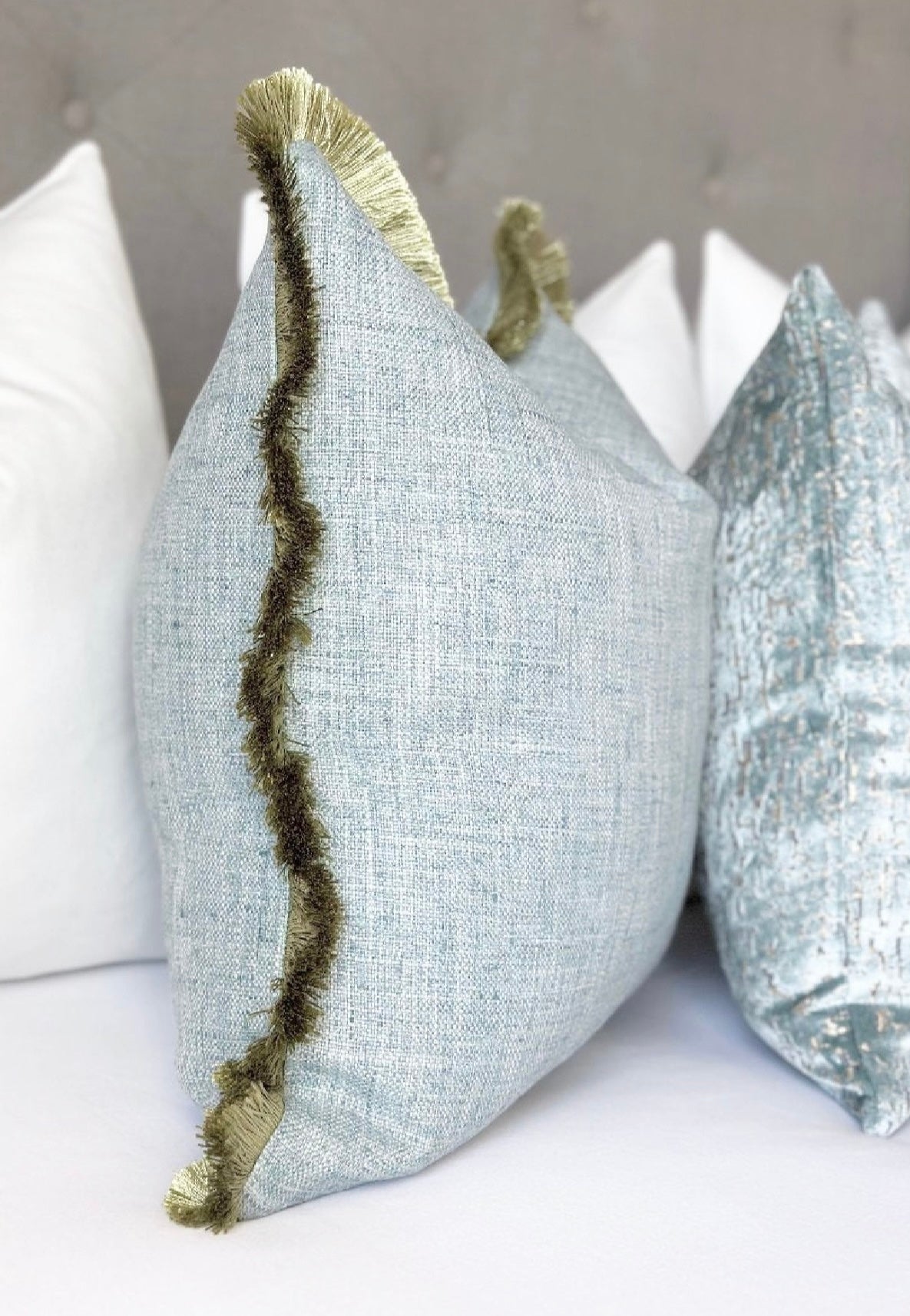 Mist blue cotton pillow green fringe detail